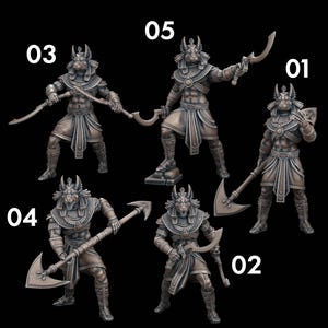 May include: Bronze-colored Anubis figurines in various poses, each holding a different weapon. The figures are numbered 01 through 05, and are set against a black background. The Anubis figures are detailed with Egyptian-style clothing and headdresses.
