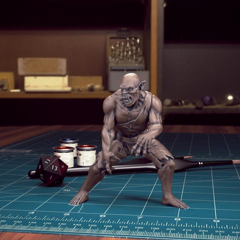 K&ouml;nnte beinhalten: Eine bemalte Miniaturfigur eines goblinartigen Wesens mit einem grimmigen Ausdruck, die auf einer gr&uuml;nen Schneidematte mit einem Lineal und Farbt&ouml;pfen steht.