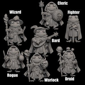 Puede incluir: Una colección de siete figuras en miniatura grises de ranas antropomórficas, cada una representando una clase de fantasía diferente: Mago, Clérigo, Luchador, Bardo, Pícaro, Brujo y Druida. Cada rana viste atuendo de clase y sostiene objetos.