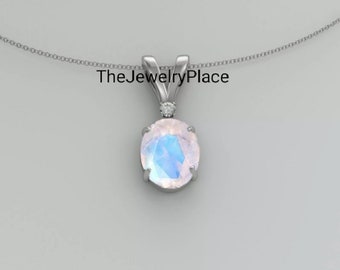 Può includere: Una collana con pendente in argento con una pietra di luna ovale e iridescente. La pietra di luna è incastonata in una lunetta d'argento con un piccolo diamante. Il testo "TheJewelryPlace" è visibile.