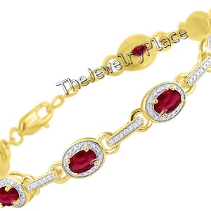 Könnte beinhalten: Ein goldenes Armband mit ovalen roten Rubinen und kleinen Diamanten, die in einem goldenen Rahmen gefasst sind. Das Armband hat einen Karabinerverschluss.