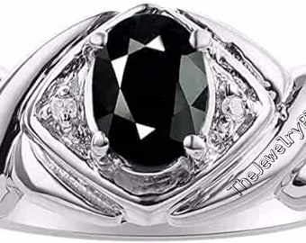 May include: A silver ring with a large black oval gemstone surrounded by smaller white gemstones. The ring has a textured band and the words "The Jewelry Place" are engraved on the side.