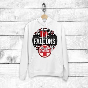 May include: White hoodie with a black and red circle design. The circle features a red "M" with a black outline, the words "FALCONS" in black, and a red and white checkered circle with the words "Nurse Ratched" in white.