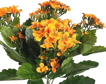 May include: A bouquet of artificial Kalanchoe flowers featuring vibrant orange petals and clusters of small, four-petaled blossoms. The arrangement includes multiple stems with deep green, scalloped-edged leaves attached to a central green stem.