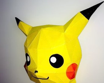 May include: A yellow papercraft Pikachu mask with black ears and red cheeks. The mask is made of folded paper and has a 3D effect.