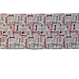 Könnte beinhalten: Weiße Stoff-Hundetrainings-Leckerli-Tasche mit rotem und schwarzem Text, der "I woof, I fetch, I stay, I bark, I sit" lautet. Die Tasche hat zwei Metallringe an den Seiten.
