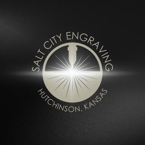 May include: A white logo on a black background with the text "Salt City Engraving" in a circle around a laser beam graphic. The text "Hutchinson, Kansas" is below the circle.