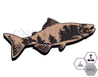 May include: A brown wooden silhouette of a salmon with a forest scene inside. The salmon is facing right and has a detailed design. The forest scene is black and white.