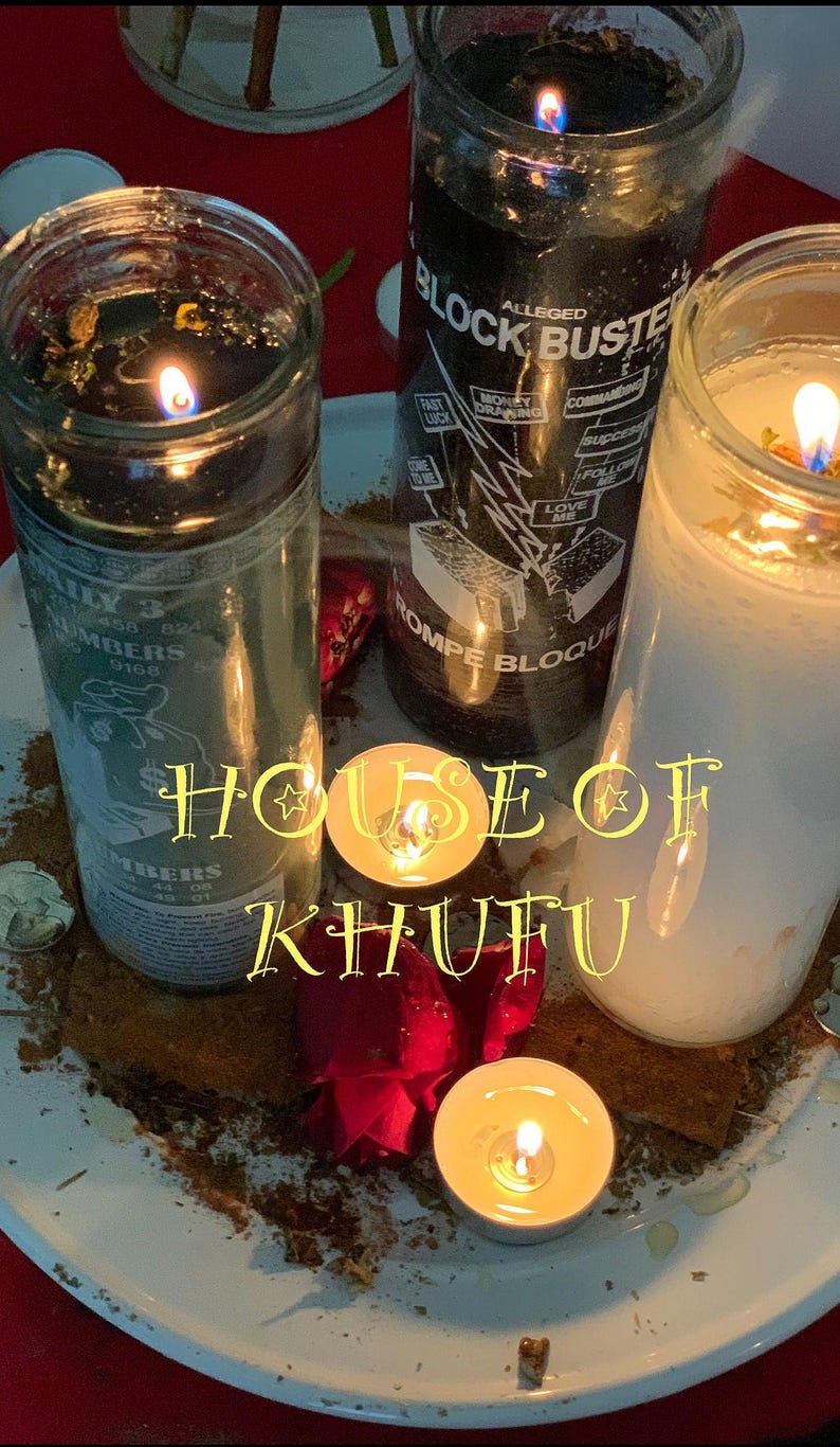 Puede incluir: Tres tarros de velas de vidrio con cera negra, blanca y verde. Las velas est&aacute;n encendidas y las llamas son visibles. Las velas est&aacute;n sobre un plato blanco con una flor roja y una peque&ntilde;a vela de t&eacute;. El texto "HOUSE OF KHUFU" est&aacute; escrito en letras amarillas en el plato.