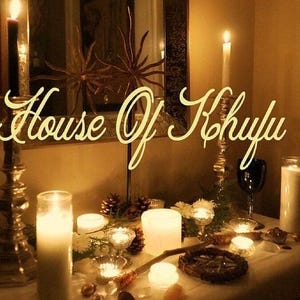 Puede incluir: Una mesa puesta con velas, cristales y un pentagrama de madera. El texto "House of Khrylu" est&aacute; escrito en letras doradas sobre la mesa.