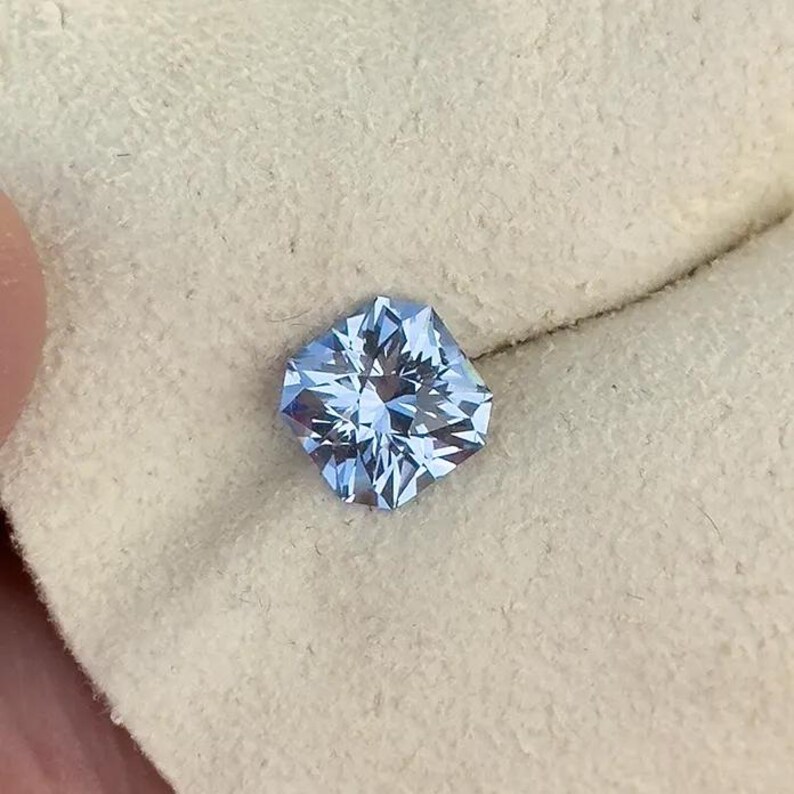 May include: A light blue gemstone with a square shape and a faceted cut.