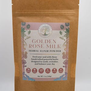 Op de afbeelding: Een bruine papieren zak met een label waarop "Golden Rose Milk Herbal Elixir Powder" staat. Het label heeft een roze en wit bloemenmotief met een boom en de woorden "Area of Light Apothecary". Het label bevat ook een lijst met voordelen, zoals "Holistic", "Powerful" en "Made with Love". De zak bevat 142 g poeder.