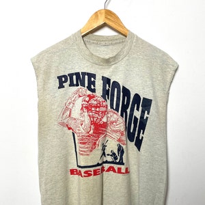 May include: A gray sleeveless t-shirt with a red and blue graphic of a baseball player and the text "Pine Forge Baseball".