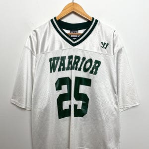 Puede incluir: Una taza de cerámica blanca con un asa negra y el texto "But First, Coffee" en negro, con una fuente de estilo manuscrito. La taza está sobre una superficie blanca.