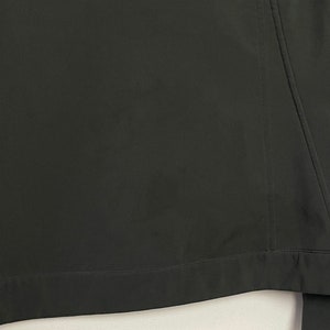 May include: A dark green jacket with a zipper closure and a seam down the back.