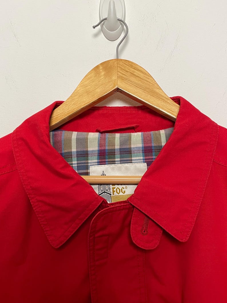 Peut inclure: Une veste rouge avec une doublure &agrave; carreaux et un logo "Fog" dor&eacute; sur le col.