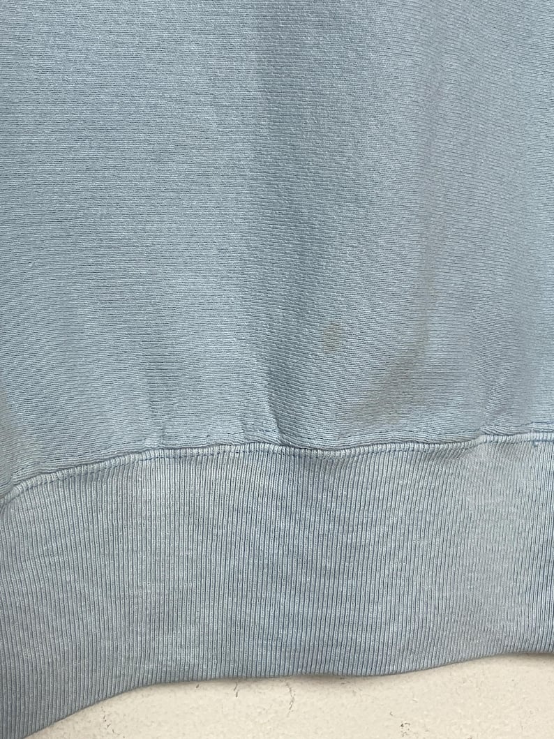K&ouml;nnte beinhalten: Ein hellblauer Pullover mit geripptem Saum.