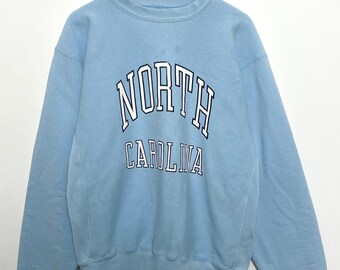 Sudadera vintage de los años 90 con cuello redondo y gráfico de los Tar Heels de la Universidad de Carolina del Norte en azul con tejido inverso de Champion (talla grande)