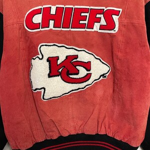 Puede incluir: Chaqueta de cuero roja con cuello y pu&ntilde;os a rayas negras y rojas. La parte posterior de la chaqueta presenta un gran logotipo "CHIEFS" blanco y rojo con un logotipo "KC" blanco y rojo m&aacute;s peque&ntilde;o debajo.