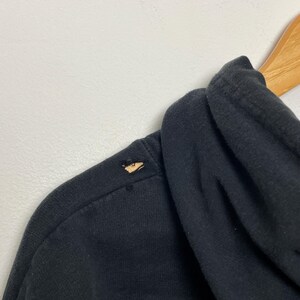 May include: Black hooded sweatshirt with a small tear on the shoulder.