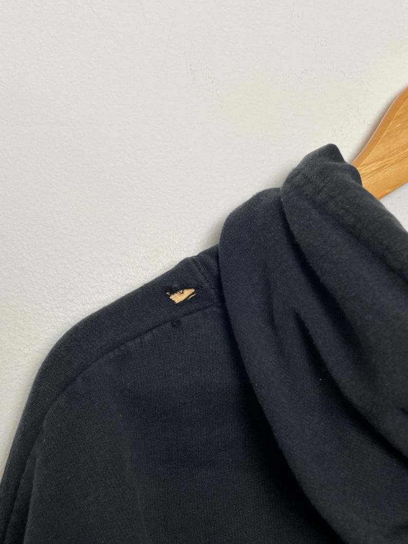 May include: Black hooded sweatshirt with a small tear on the shoulder.