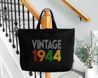 May include: Black canvas tote bag with the text "Vintage 1944" in a retro style font. The numbers are outlined in red, orange, green, and yellow.