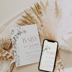 May include: A baby shower invitation with a floral design and the text "BABY in bloom" and "Regina Walters". The invitation is on a white card with a floral border. The invitation is next to a smartphone with a similar design and text.