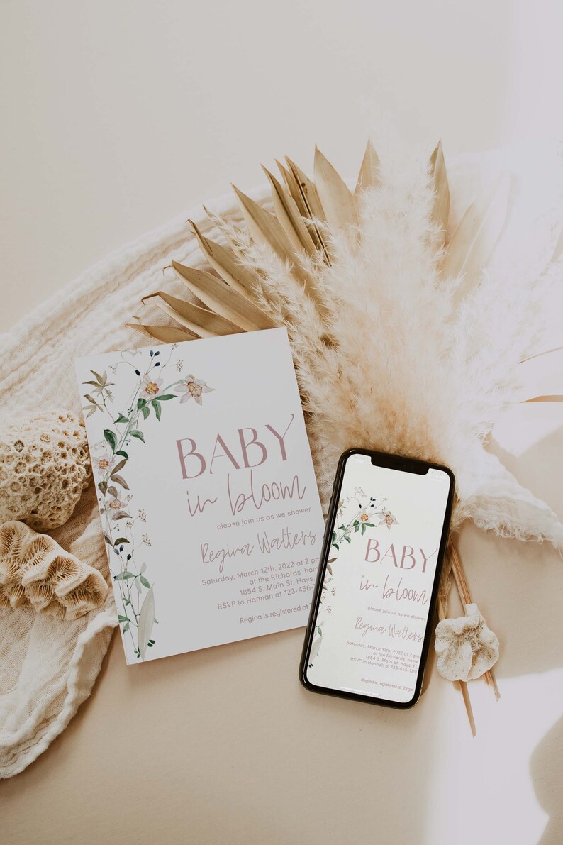 May include: A baby shower invitation with a floral design and the text "BABY in bloom" and "Regina Walters". The invitation is on a white card with a floral border. The invitation is next to a smartphone with a similar design and text.