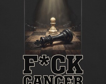 May include: A black t-shirt featuring a graphic of a white pawn standing on a chessboard with a fallen black king. The text F*CK CANCER is printed in bold white letters with a black outline below the chess scene on the dark fabric.