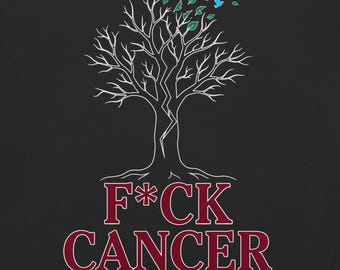 May include: A black graphic t-shirt featuring a white line-art tree with a split trunk, green leaves, and blue birds. Below the tree, the text reads F*CK CANCER in large maroon letters, followed by the white text We Don't Forget. We Don't Stop.