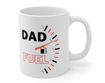 May include: White ceramic coffee mug with a black and red fuel gauge graphic that reads "DAD FUEL". The needle on the gauge is pointing to full.