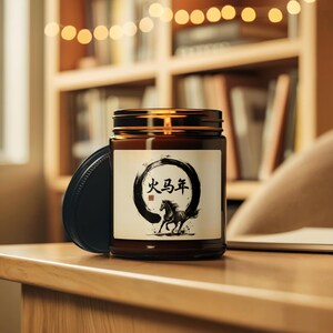 May include: A brown glass jar candle with a black lid. The label features a black circular design with Chinese characters and a running horse illustration. The candle sits on a wooden surface.