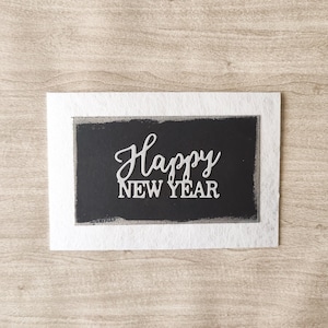 Biglietto nero "Happy New Year" su sfondo argento, Elegante biglietto di auguri di Capodanno, Biglietto argento con delicata lucentezza