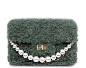 Könnte beinhalten: Eine kleine, grüne, flauschige Handtasche mit einem goldenen Verschluss und einem Perlenkettenriemen.