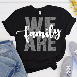 Puede incluir: Camiseta negra con un gr&aacute;fico blanco que dice "We Are Family" en una fuente desgastada.