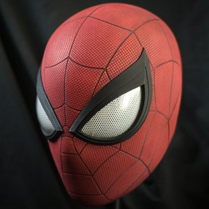 Puede incluir: Una m&aacute;scara de Spider-Man roja y negra con una pieza de ojo de malla blanca.