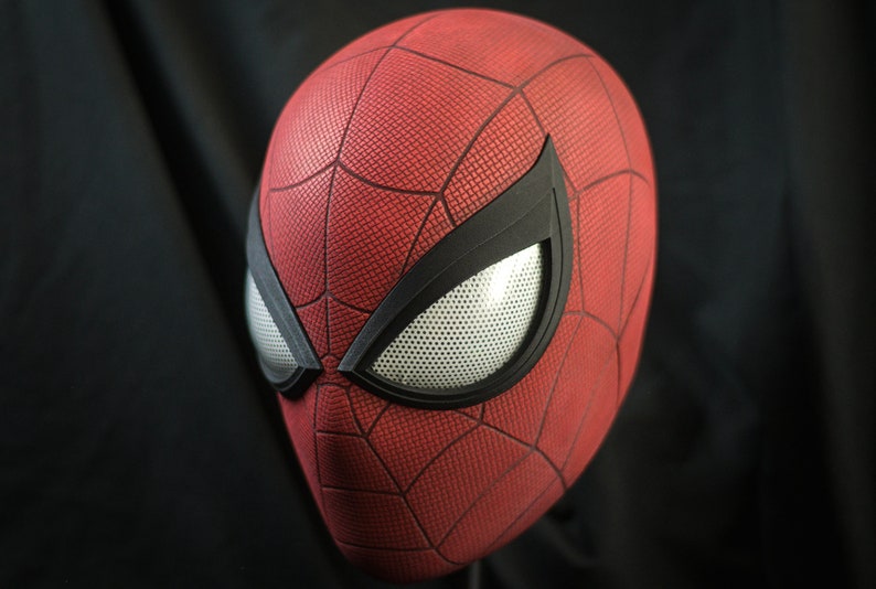 Puede incluir: Una m&aacute;scara de Spider-Man roja y negra con una pieza de ojo de malla blanca.