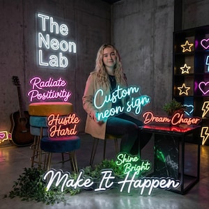Puede incluir: Una variedad de letreros de neón con frases motivacionales y un nombre comercial. Los letreros son de varios colores, incluyendo blanco, rosa y verde. Las frases incluyen "The Neon Lab", "Radiate Positivity", "Hustle Hard", "Dream Chaser", "Shine Bright" y "Make It Happen".