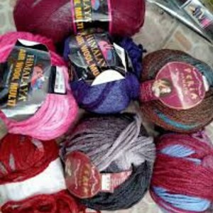May include: Assortment of colorful yarn balls in various shades of pink, red, blue, purple, and brown. The yarn is made of wool and is suitable for knitting or crocheting.