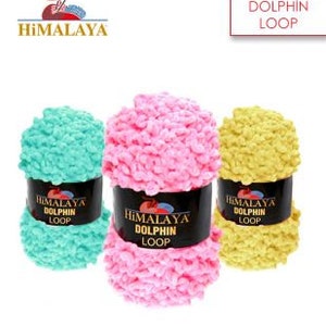 Peut inclure: Trois pelotes de fil Himalaya Dolphin Loop en différentes couleurs : bleu clair, rose et jaune. Le fil est un poids volumineux et a une texture duveteuse.