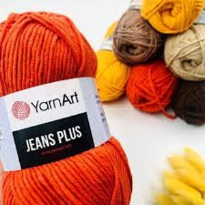 May include: Orange yarn ball labeled "YarnArt Jeans Plus" with other yarn balls in various colors in the background.
