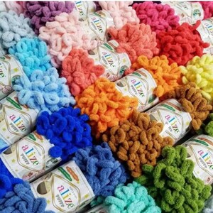 Peut inclure: Assortiment de pelotes de laine colorées dans différentes nuances de bleu, vert, orange, rose, rouge et marron. La laine est un type moelleux et texturé appelé "alize puffy".