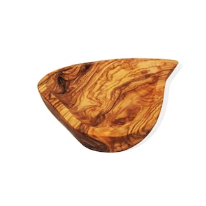 Può includere: Una piccola ciotola di legno a forma di lacrima. La ciotola è realizzata in legno di ulivo e ha una finitura naturale e rustica. La venatura del legno è visibile e aggiunge al carattere unico della ciotola.