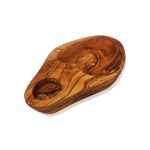 Op de afbeelding: Een houten serveerschaal met twee kleine kommen die in het oppervlak zijn gegraveerd. De schaal is gemaakt van olijfhout en heeft een natuurlijke, rustieke afwerking.