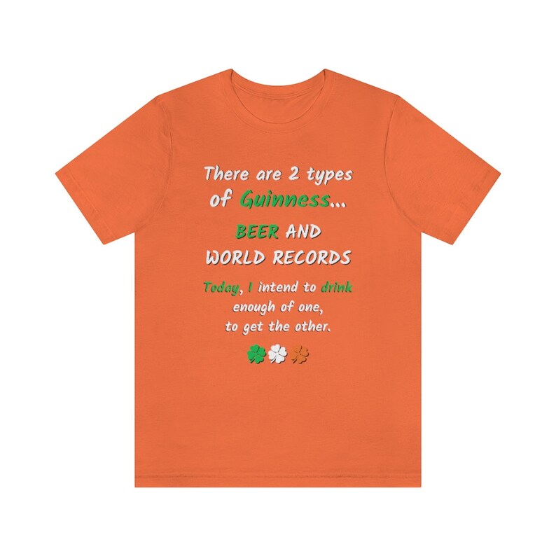 K&ouml;nnte beinhalten: Orangefarbenes T-Shirt mit einem gr&uuml;nen und wei&szlig;en Kleeblatt-Design. Der Text auf dem Shirt lautet "There are 2 types of Guinness... BEER AND WORLD RECORDS. Today, I intend to drink enough of one, to get the other."