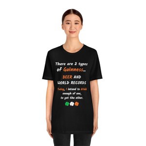 K&ouml;nnte beinhalten: Schwarzes T-Shirt mit einem wei&szlig;en Aufdruck, der lautet: "There are 2 types of Guinness... BEER AND WORLD RECORDS. Today, I intend to drink enough of one, to get the other." Die Grafik enth&auml;lt auch drei Kleebl&auml;tter.