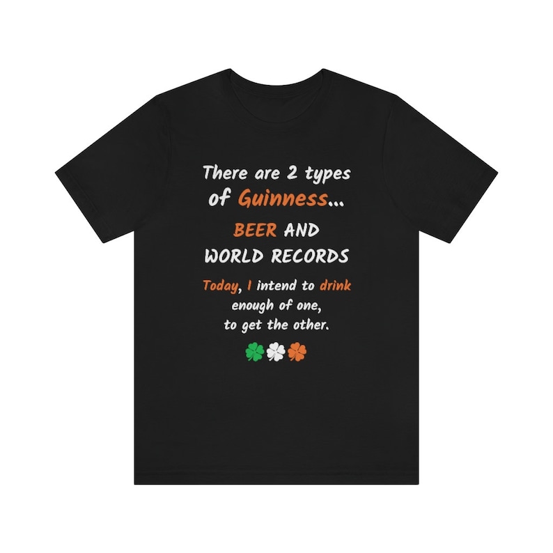 K&ouml;nnte beinhalten: Schwarzes T-Shirt mit wei&szlig;em Text, der lautet: "There are 2 types of Guinness... BEER AND WORLD RECORDS. Today, I intend to drink enough of one, to get the other." Unter dem Text befinden sich vier gr&uuml;ne Kleebl&auml;tter mit orangefarbenen Zentren.