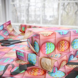 May include: Two pink gift boxes wrapped in Easter egg patterned paper. The boxes are stacked on top of each other and feature colorful eggs with different patterns.