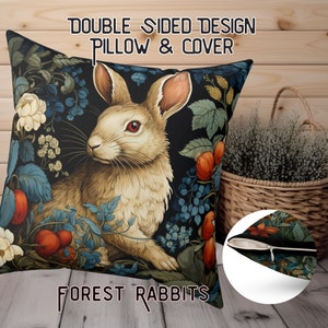 May include: Double-sided throw pillow featuring a white rabbit with red eyes surrounded by lush green foliage and red berries. The pillow has a black background and the text "FOREST RABBITS" is printed on the bottom. The back of the pillow is a dark green with a floral pattern.