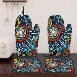 May include: A set of two oven mitts and two matching pot holders. The kitchen textiles feature a vibrant, colorful design with concentric circles and dot patterns in shades of blue, yellow, orange, and pink on a black background.